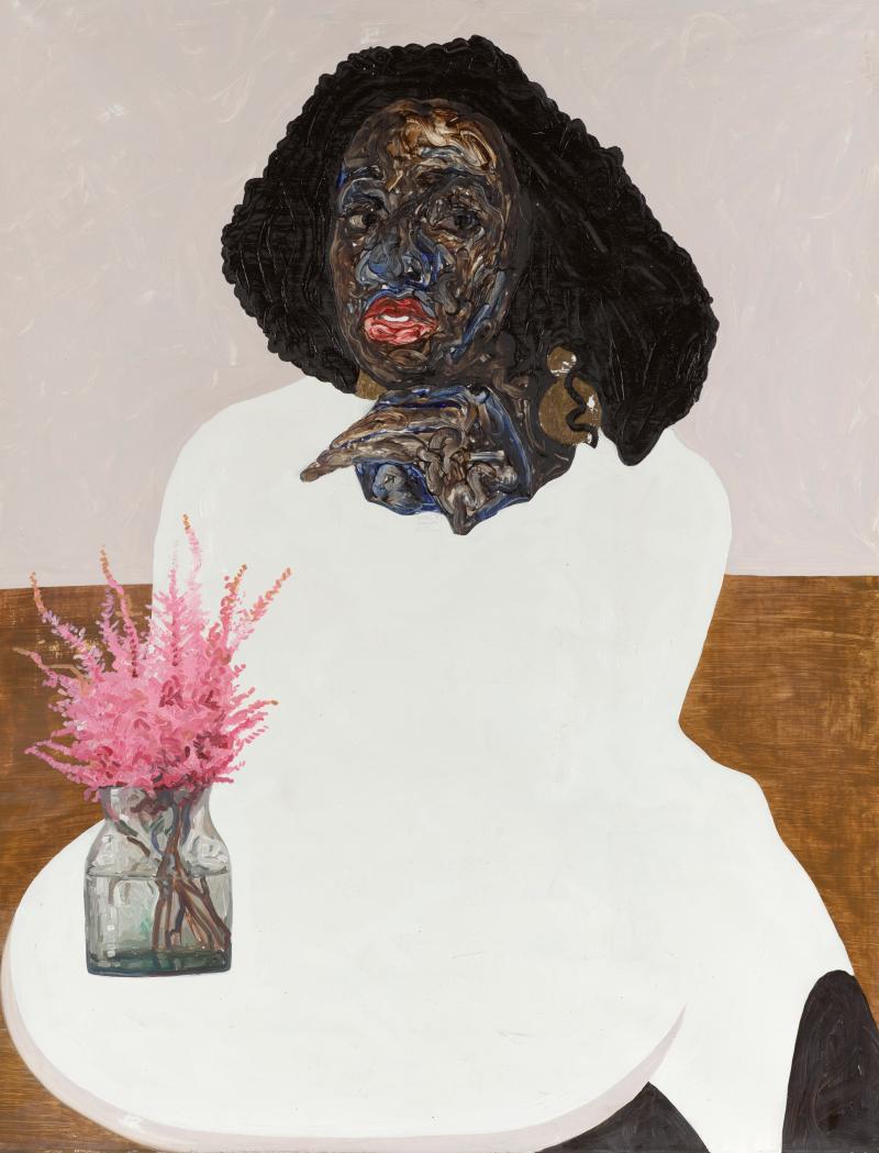 Black woman in white sitting and posing at a table