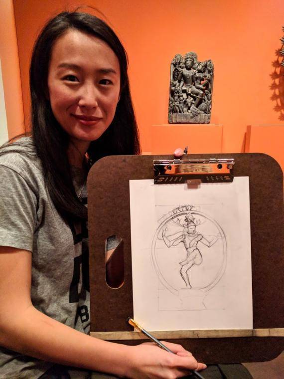 a woman holding a drawing of Shiva she drew in the Linking Asia exhibition