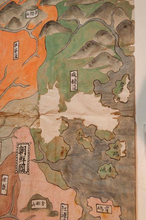 close up of Korea showing loss of copper colorant and an old repair