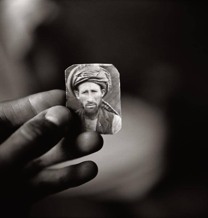 Fazal Sheikh, Abdul Aziz holding a photograph of his brother Mula Abdul Hakim, Afghan refugee village Khairabad, North Pakistan, from the series The Victor Weeps. © Fazal Sheikh