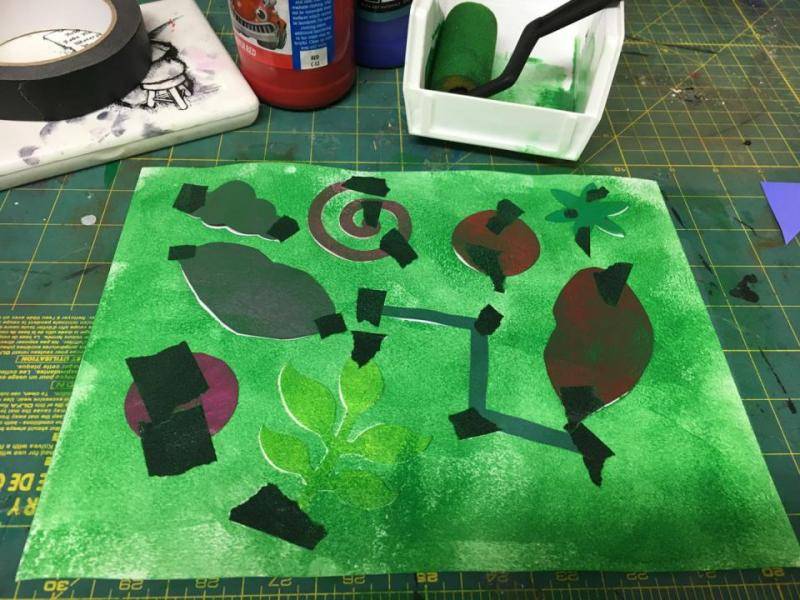 Green tempera paint is applied to the paper using a foam roller.